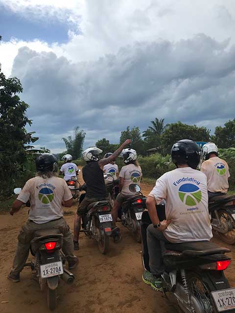 A group of people in white shirts sitting on scooters