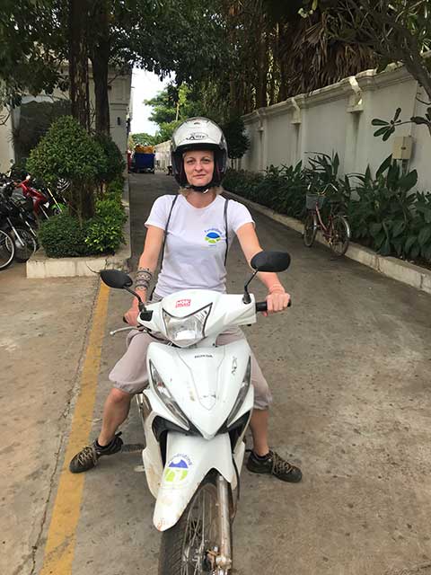 Woman sitting on a scooter with a white helmet