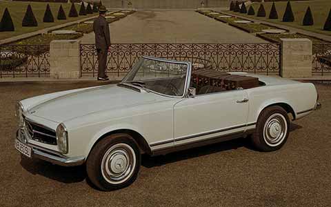 Mercedes Benz SL second generation in white in front of a garden, sepia picture