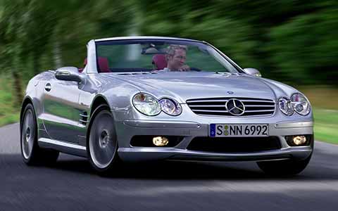 Mercedes Benz SL fifth generation in silver with open top, a man driving