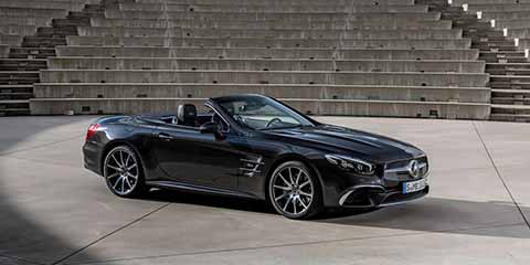 Mercedes Benz SL sixth generation in black with an open top in front of stairs