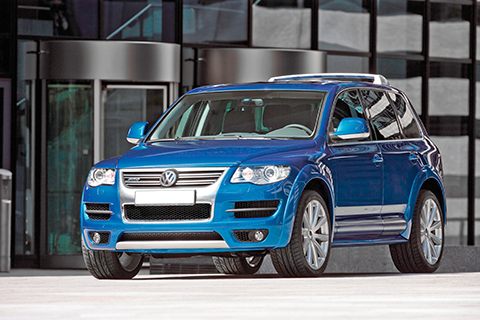 Blue metallic VW Touareg front view parking in front of a bulding