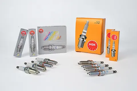 Nickel and iridium spark plugs in front of their product packages
