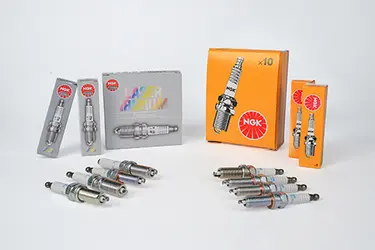 Nickel and iridium spark plugs in front of their product packages