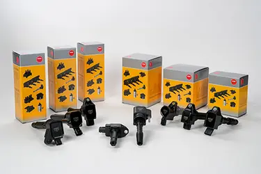 Eight different NGK ignition coils in front of their yellow boxes