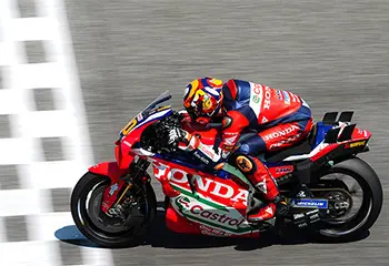 Race driver on a red Ducati riding a steep corner