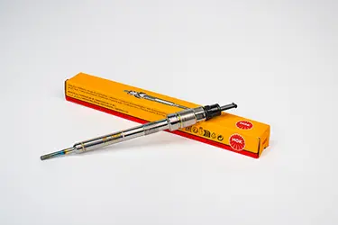 Glow plug laying on its yellow box