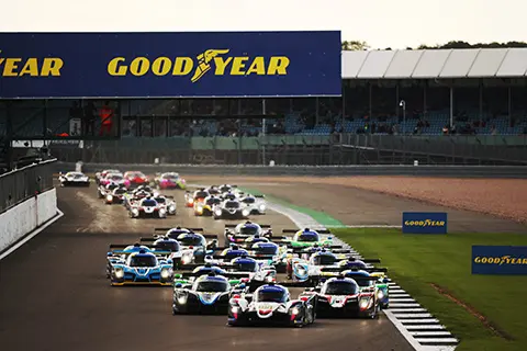 Endurance cars on a race track below a Good Year banner