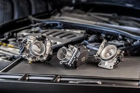 Mechanic, electric and hybrid throttle bodies on a working table in a garage